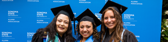 three girls in graduation caps and gowns